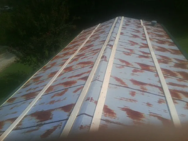 Rusted metal roof panels with new wood purlins before replacement — Storm Damage Roof Repair in Weskan by Roofing Brothers