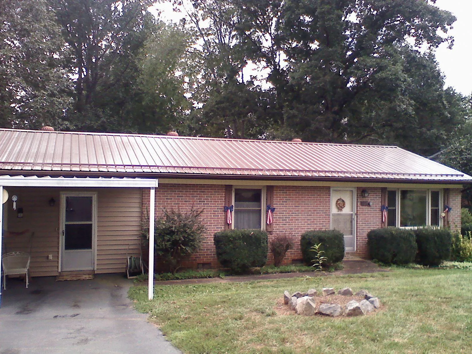 Bronze metal roof and carport on a brick ranch home — Roof Repair work by our crew in Weskan